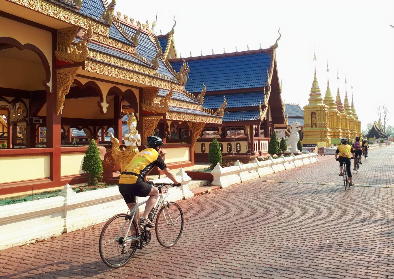 cycling group riding past Buddhist templ