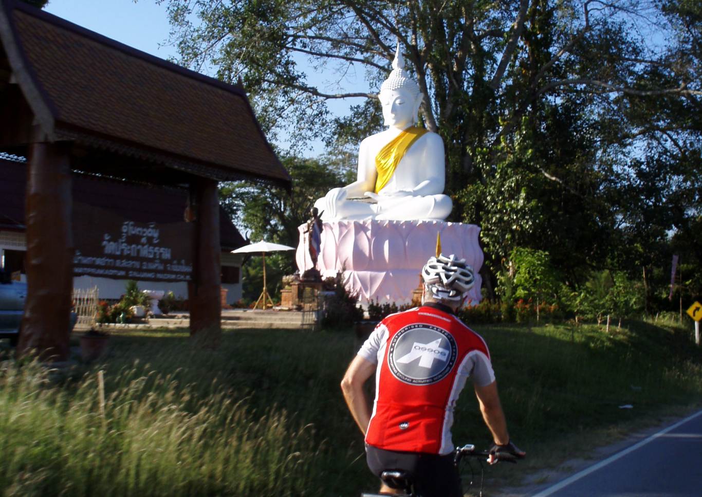 bicycling past a Buddha image at temple