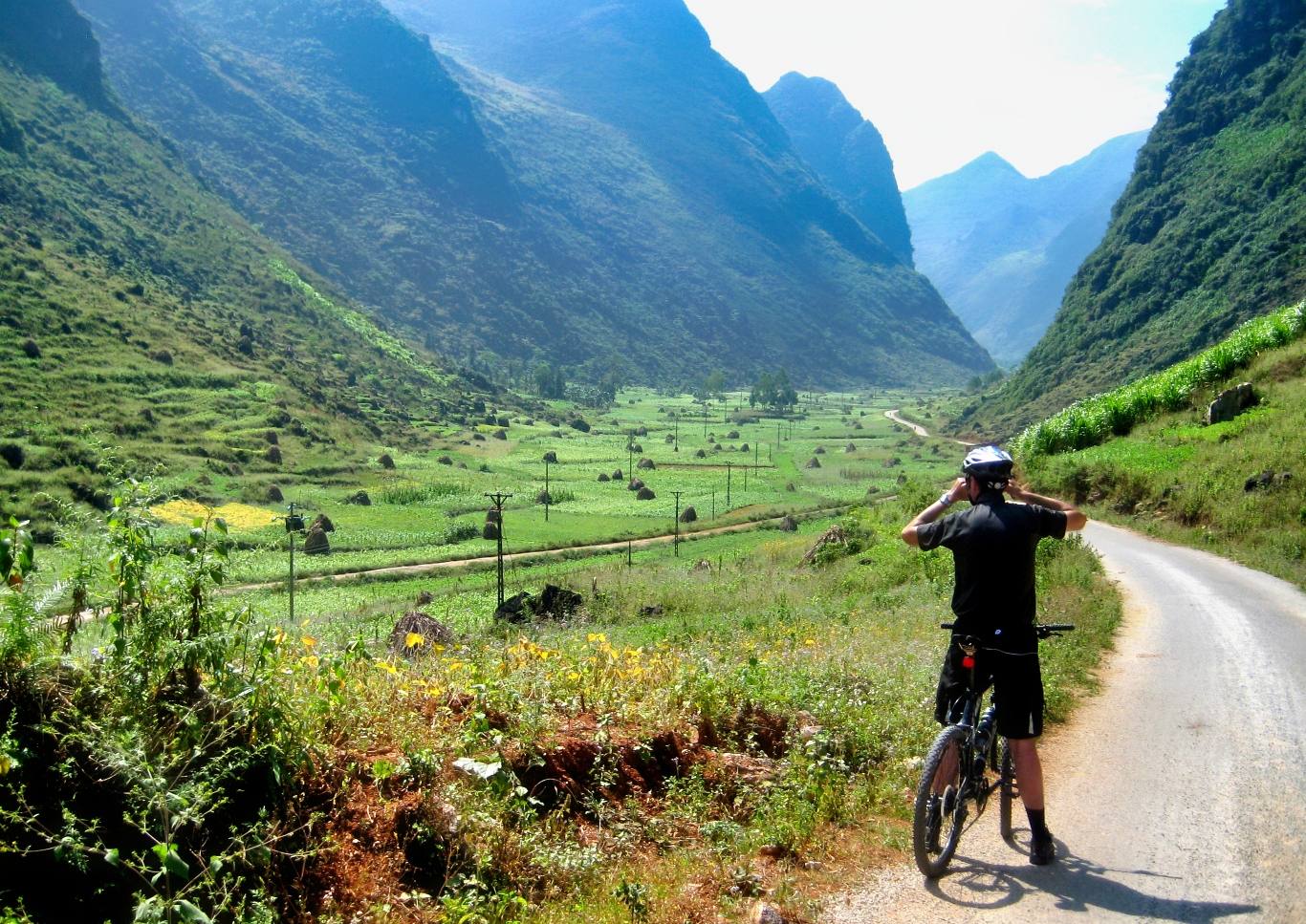 Cyclist photographing Vietnam mountain valley