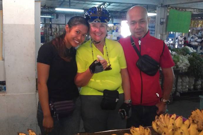 cyclists with banana vendor in fresh market