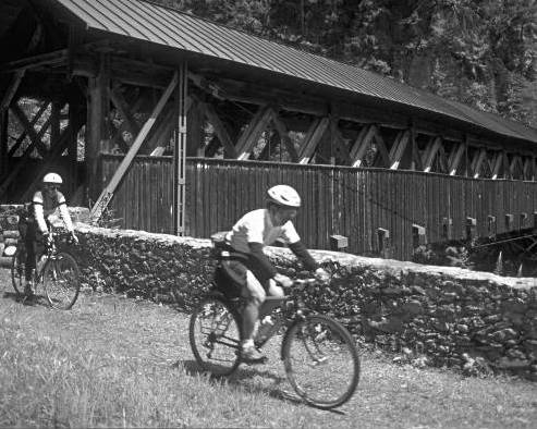 cyclists near covered bridge