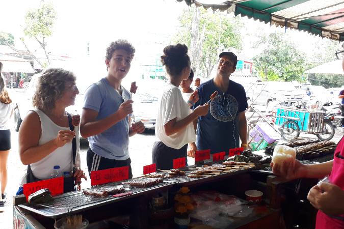 sampling street food at local market