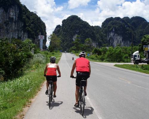 a couple of cyclists pedaling through karst landscape