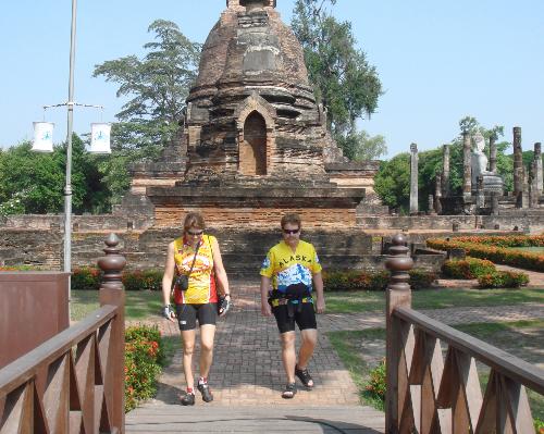 cyyclists crossing bridge from temple ruin