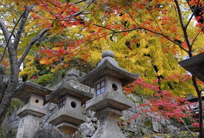 stone lanterns amid fall colors on trees