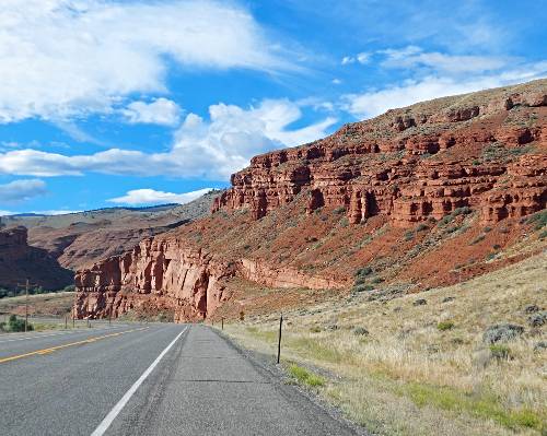 road passing by red cliffs on bluff